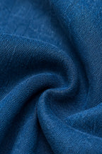 A close-up of draped blue fabric with a soft, textured weave and gentle folds.