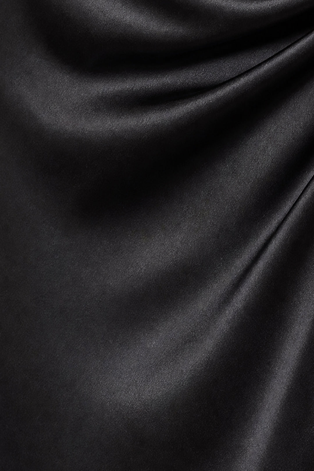 A close-up of draped black satin or silk fabric with soft folds and a subtle sheen.