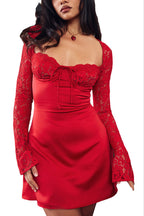 A woman wearing a red mini dress with long lace sleeves, a sweetheart neckline, and a front tie detail, shown against a plain white background.