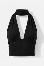 A black halter-style crop top with a deep V-neckline and gathered ruching at the bust and waist, shown on a plain light background.