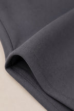 Close-up of a folded dark gray fabric garment showing the texture and fine stitching detail.