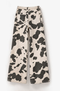 Wide-leg pants featuring a bold black and cream cow print pattern, displayed flat against a clean white background.