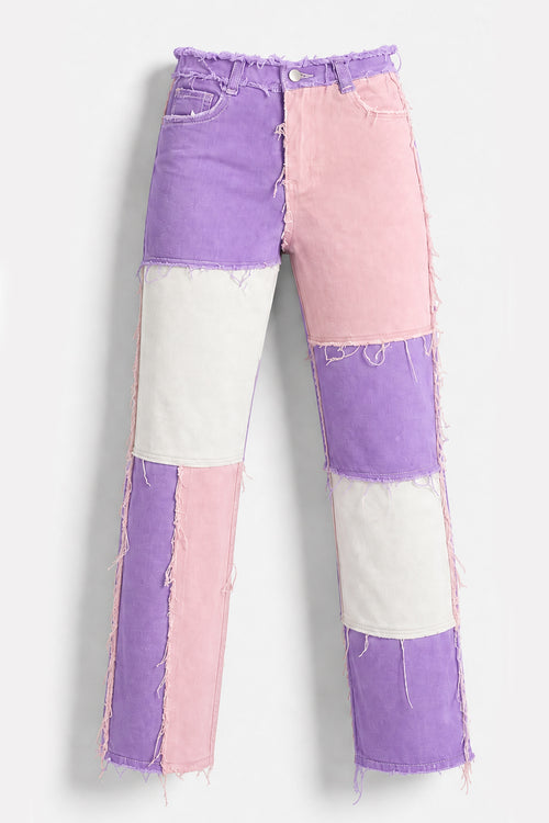 Patchwork denim jeans with a color-blocked design in purple, pink, and off-white, featuring raw frayed edges and a straight-leg silhouette.