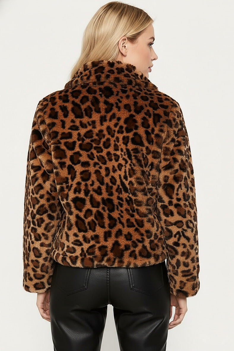 A woman shown from the back wearing a brown and black leopard-print faux fur jacket with black leather pants, against a plain light gray background.