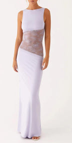 A sleeveless floor-length gown in a very pale lavender or lilac tone, featuring a sheer floral lace panel across the torso, shown on a model against a plain light background.