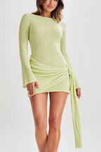 Woman wearing a light green dress with long sleeves on a white background