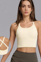 A woman wearing a cream-colored ribbed crop top sports bra with a close-up inset of the back straps, set against a solid gray background.