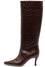 A dark brown knee-high boot with a glossy crocodile-embossed texture, featuring a pointed toe and a slim kitten heel, shown against a plain white background.