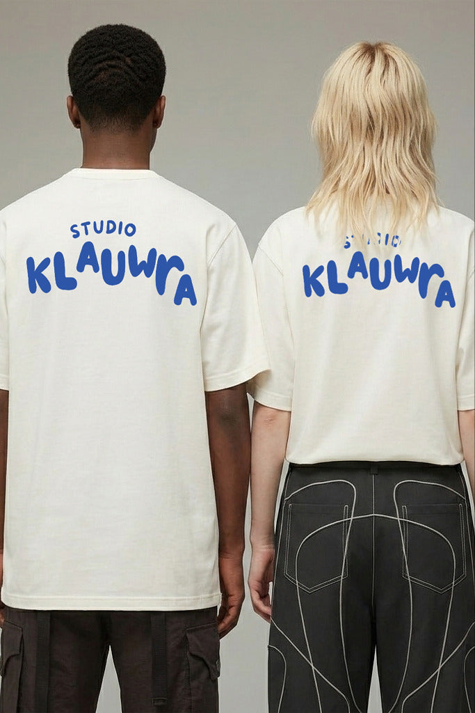 Two models shown from the back wearing matching off-white t-shirts with 'STUDIO KLAUWRA' printed in blue across the upper back, set against a plain light gray studio background.